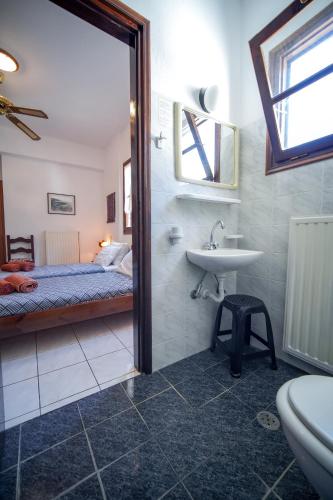 a bathroom with a bed and a sink and a toilet at Hotel Hagiati in Chorefto