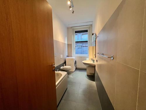 a bathroom with a toilet and a sink and a tub at Kibilù - Cozy Studio few steps from Duomo City Centre in Milan
