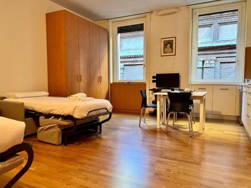 a bedroom with a bed and a table and a desk at Kibilù - Cozy Studio few steps from Duomo City Centre in Milan