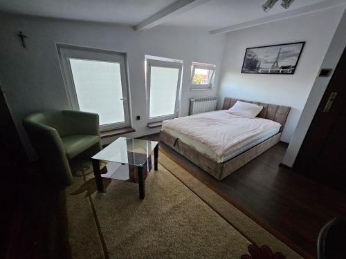a bedroom with a bed and a chair and a table at Apartament 3 in Biała Podlaska