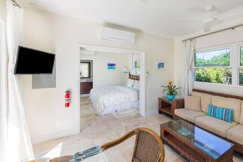 a living room with a couch and a bed at Chuchubi Cottage in Long Bay Hills
