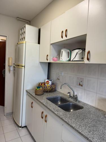 a kitchen with a sink and a refrigerator at Departamento Bloom in Bahía Blanca