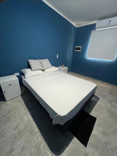 a blue bedroom with a large bed in a room at Nexo departamentos in San José