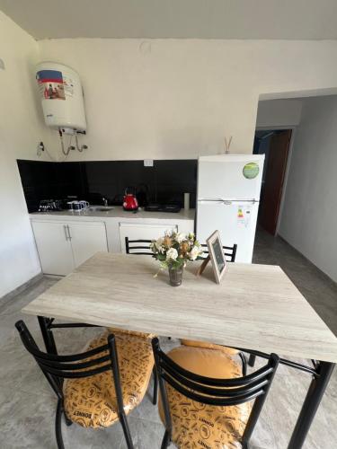 a kitchen with a table with chairs and a refrigerator at Nexo departamentos in San José