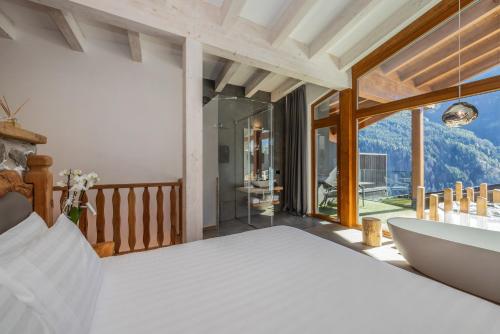 a bedroom with a bed and a large window at Hotel Chalet Al Foss - Adults Only in Vermiglio