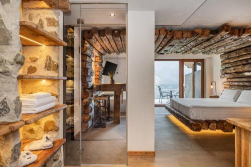 ヴェルミーリオにあるHotel Chalet Al Foss - Adults Onlyの石の壁の中にベッドが置かれた寝室