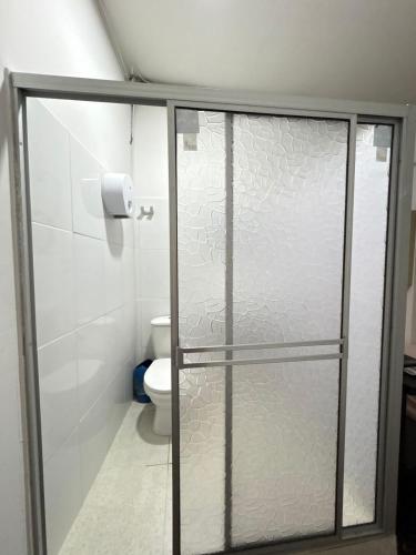ein Badezimmer mit einer Glasduschtür mit Toilette in der Unterkunft Hotel 7 in Cúcuta