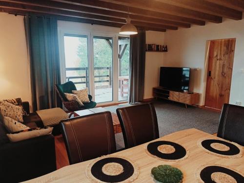 a living room with a table and chairs and a television at Domek w górach Łubinowa 6 in Międzylesie