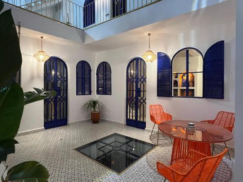 a room with a table and chairs and some windows at Riad Lyabaïana privatisé, piscine et vue mer dans la médina in Tangier