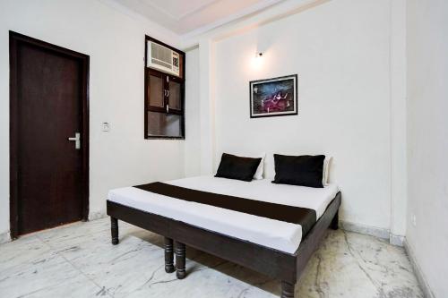 a bedroom with a bed in a white room at Hotel O Royal residency in Dera Māndi