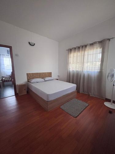 une chambre avec un lit et un parquet dans l'établissement Soley, à Port-Louis