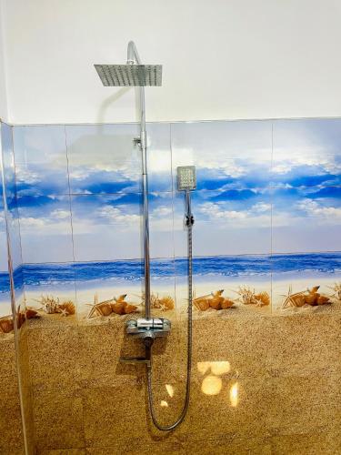 a shower in a bathroom with a view of the ocean at Racy Nature Cottage in Ella