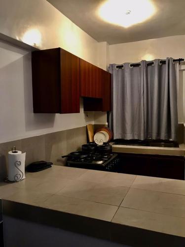 eine Küche mit Holzschränken und einem Herd mit Backofen in der Unterkunft C&N homes Kisumu in Kisumu