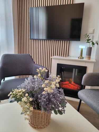 un jarrón de flores sobre una mesa con chimenea en KomfortPlus modernes Premium Apartment - Top Lage - Balkon - Parkplatz, en Bad Zwischenahn