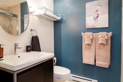 a bathroom with a sink and a toilet and a mirror at Condo Hôtel Magog Orford in Orford