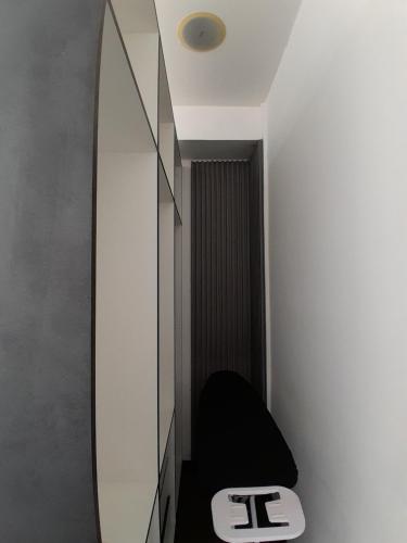 a bathroom with a mirror and a black stool at Suite de 4 camas cerca de UTPL y centro in Loja