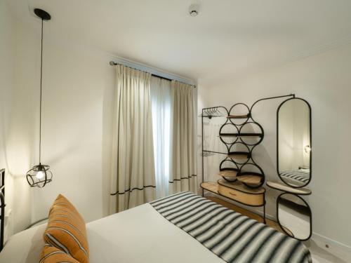 a bedroom with a bed with a shelf and a mirror at La Maquinilla fjhomefj in Jerez de la Frontera