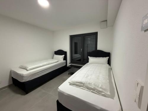 two beds in a small room with white walls at Ferienwohnung am Schloss in Erbach