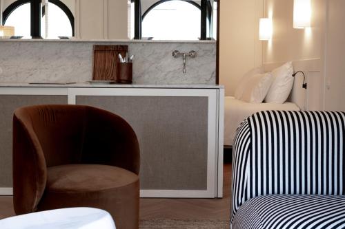 a living room with a chair and a bed at Hotel Montaigne in Ostend