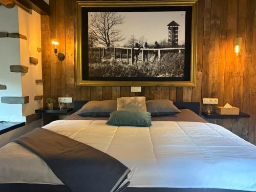 a large bed in a room with a picture on the wall at Le Gîte des Platanes in Spa