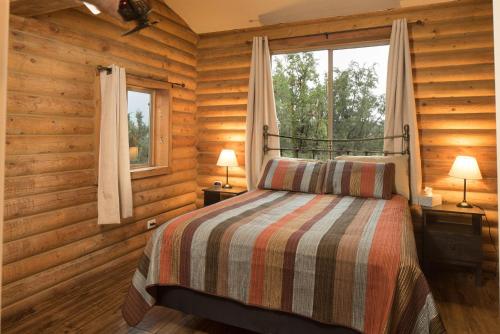 a bedroom with a bed in a log cabin at Ontario Ave Remodeled Log Cabin on 1 Acre Gateway to Grand Canyon Amazing Views in Williams