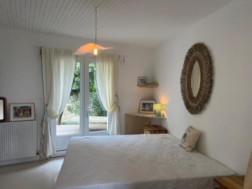 a white bedroom with a bed and a window at La Playita - 4 chambres - Plage in Le Château-dʼOléron
