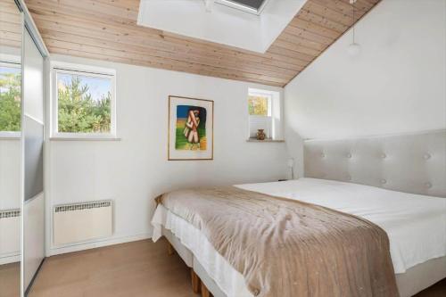 a bedroom with a bed and two windows at 2502-Nexo-Gubbegardsvejen-31 in Neksø