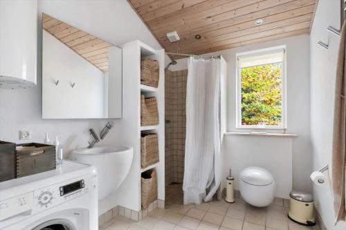 a white bathroom with a toilet and a window at 2502-Nexo-Gubbegardsvejen-31 in Neksø