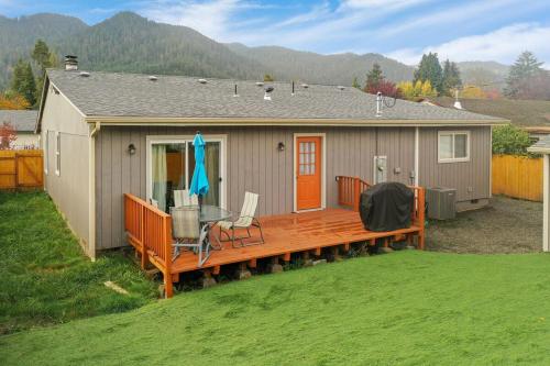 a house with a deck with a table and chairs at Mountain view, 5-bedroom home with sauna in Oakridge