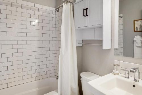 a bathroom with a white shower curtain and a sink at Mountain view, 5-bedroom home with sauna in Oakridge