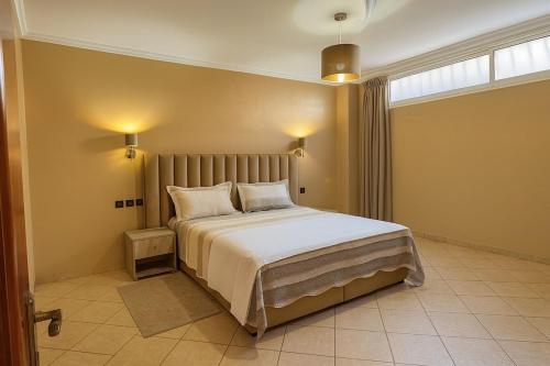 a bedroom with a large bed with white sheets and pillows at Luxury apartment with garden view in Agadir
