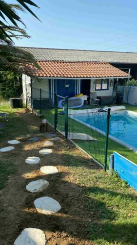 a fence next to a swimming pool next to a house at Relais Ganderats in Came