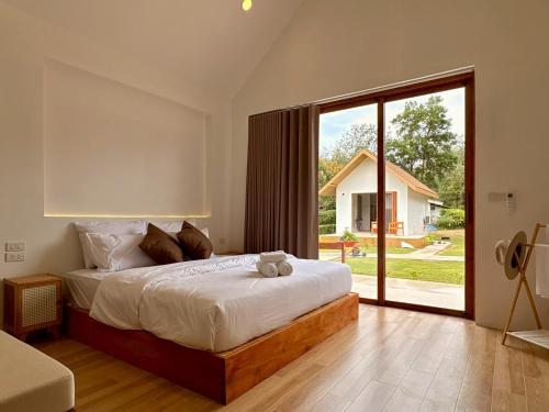 a bedroom with a large bed and a large window at The Lodge at Koh Kood in Ko Kood