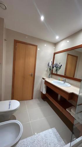 ein Badezimmer mit zwei Waschbecken und einem großen Spiegel in der Unterkunft Wave House in Strand Praia da Rocha