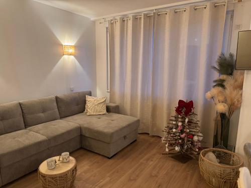 a living room with a couch and a christmas tree at Wimdream , havre de paix cosy, à deux pas de la mer et du centre ville in Wimereux