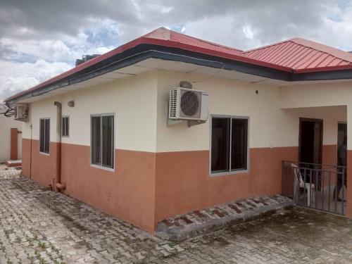 una casa con techo rojo en Richbee Hotel and Suites, en Abuja