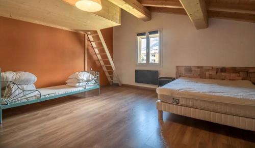 a large room with two beds and a staircase at Chalet d'Aussois Lerovi in Aussois