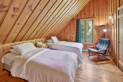 ラック・シュペリュールにあるLe Bois Dormantのベッド2台と椅子が置かれた部屋