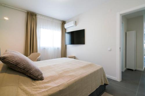 a bedroom with a large bed and a television at Rooftop Alvor Apartment by Moje Holiday in Alvor