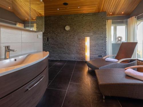 a bathroom with a tub and a chair and a couch at Sagard - Ferienhaus Rubin in Sagard