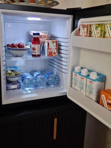 una nevera abierta llena de comida y leche en La casa di Hermes, en Imola