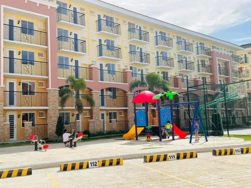 a apartment building with a playground in front of it at Rafaels Staycation at Arezzo in Davao City