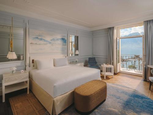 a bedroom with a large bed and a large window at Fairmont Le Montreux Palace in Montreux