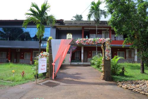 un ingresso a un edificio con arco fiorito di Kamath regency and cottages marriage Hall a Dharmastala