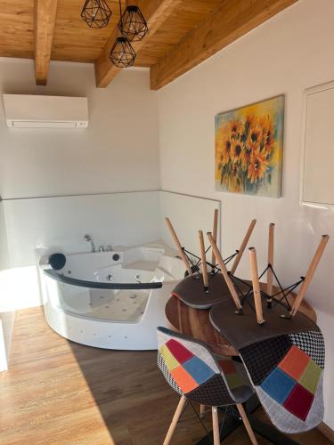 a room with a tub and a table and chairs at Ana&Borl House in Gradišča