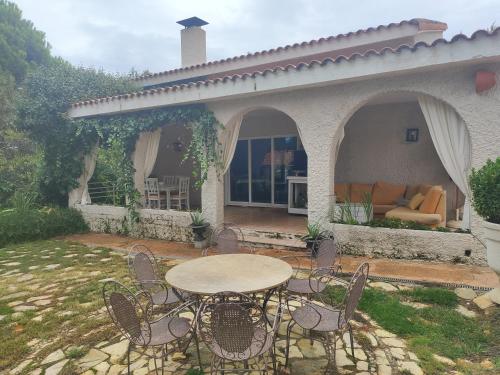 La Cubertilla en Madrid في Navas del Rey: فناء مع طاولة وكراسي وأريكة