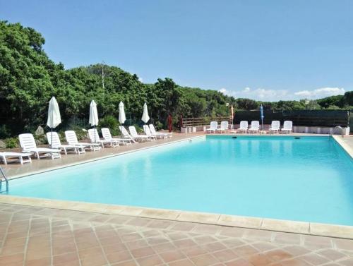 een groot zwembad met ligstoelen en parasols bij Welcome to Portoscuso in Portoscuso