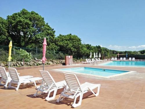 een groep witte stoelen en een zwembad bij Welcome to Portoscuso in Portoscuso