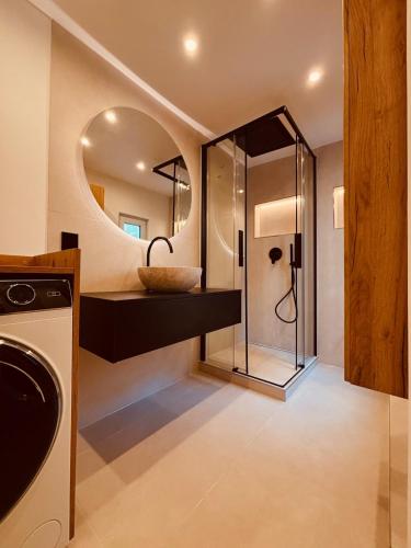 een badkamer met een douche met wastafel en spiegel bij Luxury in Eimsbüttel in Hamburg