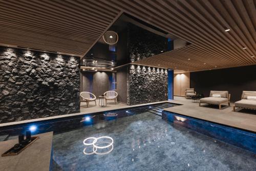 セルヴァ・ディ・ヴァル・ガルデーナにあるMuliné Lodgeの石壁のお部屋内のスイミングプール